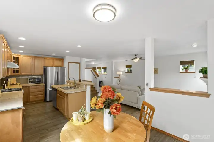 View from dining room to kitchen, living room, and staircase.