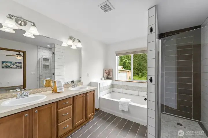 Primary suite bathroom features soaking tub, standing shower, two person vanity, and walk-in closet.
