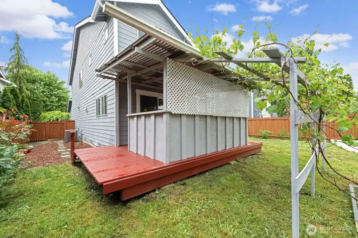 Back yard features covered deck, garden with fruit trees, shed, and greenhouse.