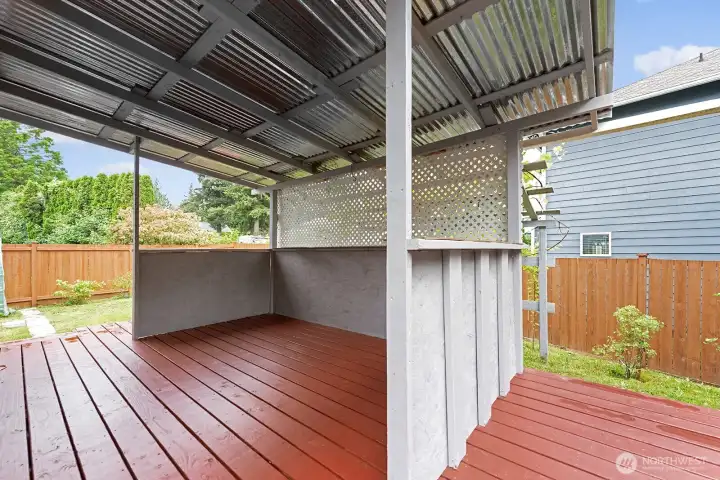 Back yard features covered deck, garden with fruit trees, shed, and greenhouse.