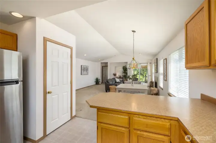 A view from the kitchen through the dining and living rooms.  Pantry on left.