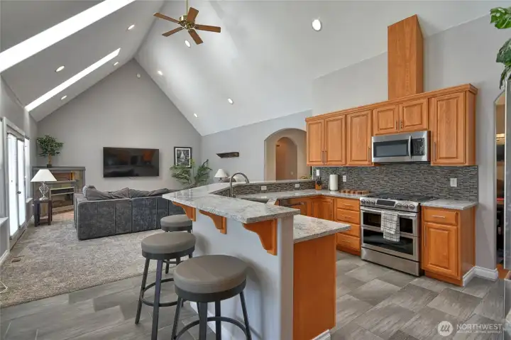 Kitchen looking into living room, cathedral ceilings with skylights make the room look spacious and bright. Kitchen looking into living room, cathedral ceilings with skylights make the room look spacious and bright.