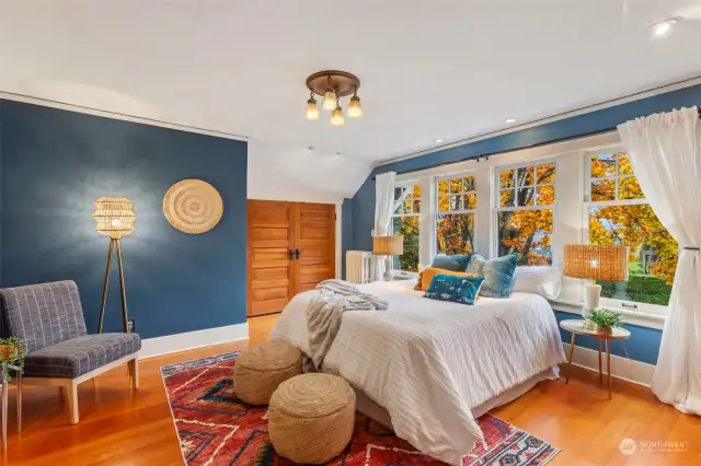 Large primary bedroom with huge windows.