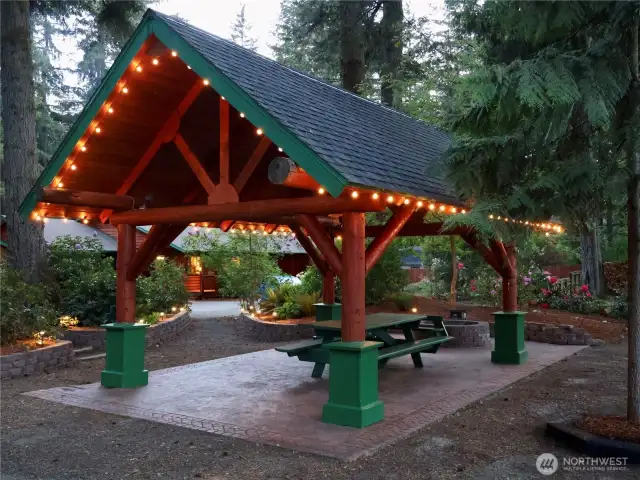 Covered outdoor entertainment pavillion with decor stamped concrete and firepit.