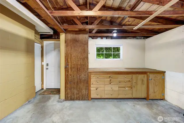Spacious garage with work area and storage. Can even store items in the rafters. Separate doors to both outside and to interior of house.