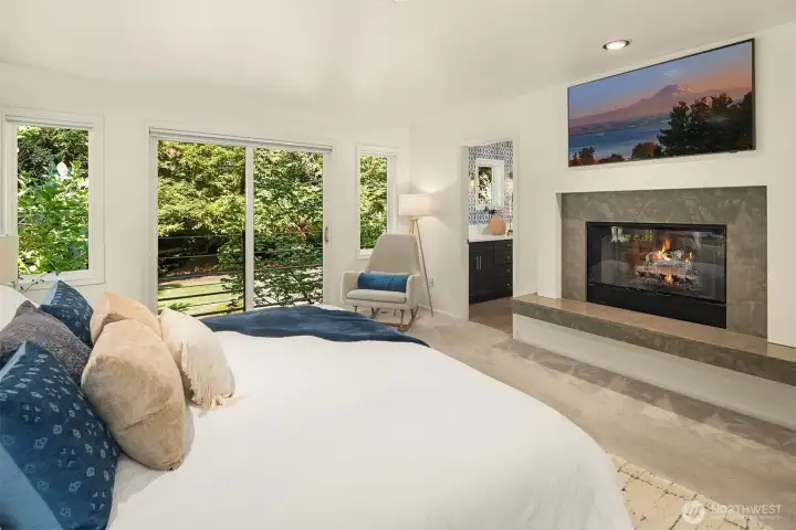 Wood-burning fireplace with gas starter in the primary bedroom.