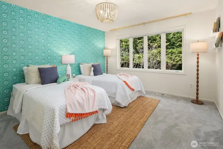 Third bedroom upstairs with a colorful statement wall, large windows & closet with bi-fold doors