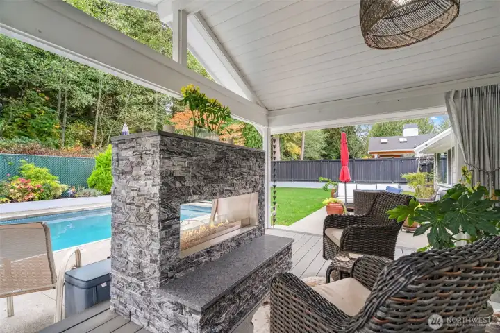 Covered outdoor living space with fireplace. Perfect for entertaining or relaxing by the fire.