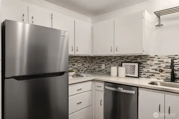 New stainless refrigerator and dishwasher, quartz counter tops, designer back splash tiles. Contemporary under-mount sink, and updated lighting makes this Kitchen the one you want to spend time in.