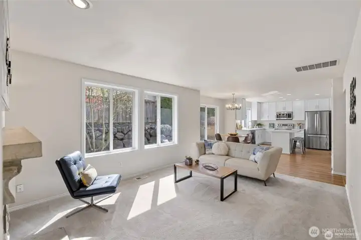 Experience the ultimate in modern living with an open-concept family room and kitchen designed for connection. Bathed in bright, natural light, this expansive space feels both grand and incredibly welcoming.  ?The brand-new kitchen—boasting modern finishes and a functional layout—flows effortlessly into the cozy family room, making it the perfect hub for daily life or weekend entertaining. At the center of it all, a warm gas fireplace serves as a stunning focal point, offering the perfect glow for chilly PNW evenings. Whether you're prepping a meal or relaxing on the sofa, this sun-drenched sanctuary is where your best memories will be made.