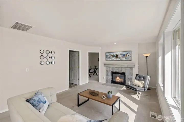 Experience the ultimate in modern living with an open-concept family room and kitchen designed for connection. Bathed in bright, natural light, this expansive space feels both grand and incredibly welcoming.  ?The brand-new kitchen—boasting modern finishes and a functional layout—flows effortlessly into the cozy family room, making it the perfect hub for daily life or weekend entertaining. At the center of it all, a warm gas fireplace serves as a stunning focal point, offering the perfect glow for chilly PNW evenings. Whether you're prepping a meal or relaxing on the sofa, this sun-drenched sanctuary is where your best memories will be made.