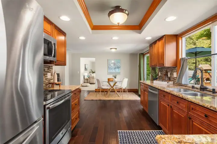 A lovely kitchen with plenty of storage and views of the fenced backyard and deck