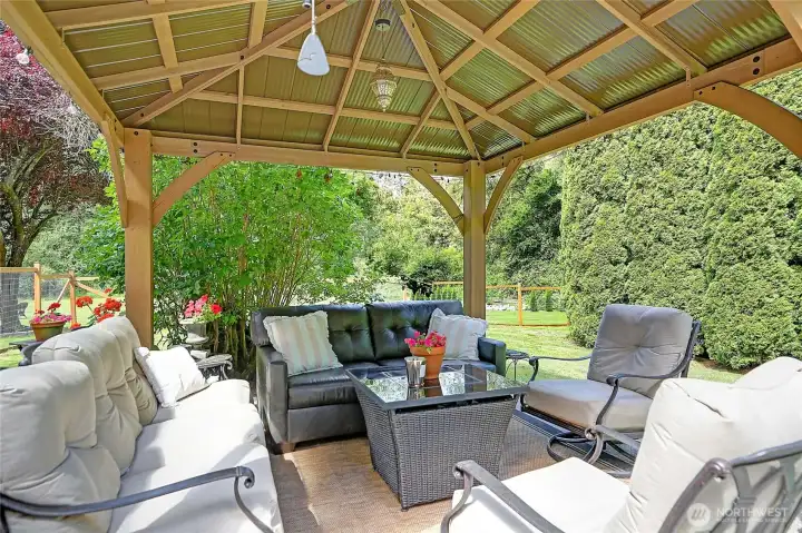 An expansive back patio is highlighted by a stunning pergola, creating an elegant outdoor retreat ideal for entertaining, outdoor dining, or unwinding while taking in the beautiful surroundings.