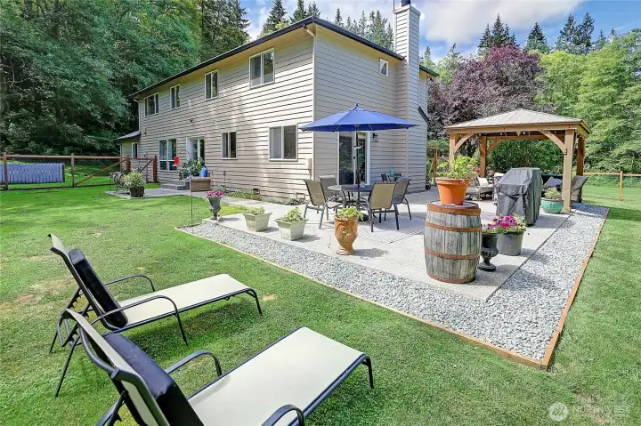 Spacious back patio with a charming pergola creates the perfect outdoor living space for entertaining, dining al fresco, or simply relaxing while enjoying the peaceful surroundings.