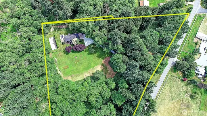 Sweeping aerial view showcasing the home's location, spacious lot, and surrounding landscape.