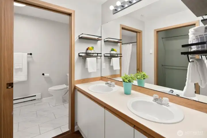 Primary bathroom with double vanity and soaking tub.