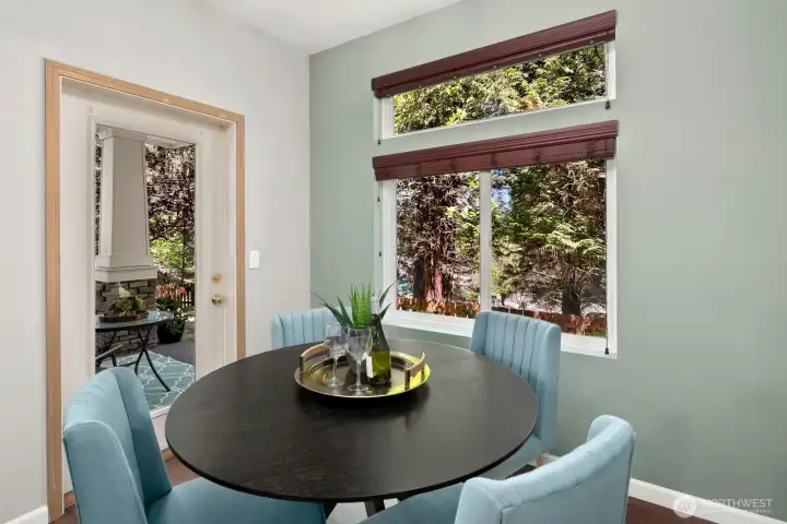 Beautiful dining space overlooking trees and a community park.