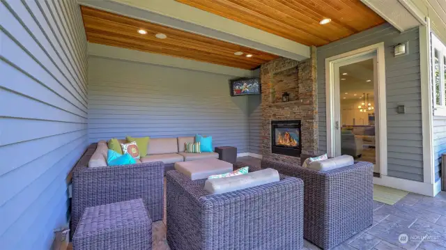 Covered outdoor living area off the great room with the dual-sided fireplace.