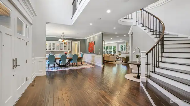 Open and airy foyer with breezeway above and handsome hardwood flooring throughout the main living spaces.
