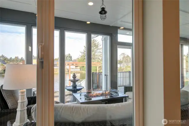 Looking out from the living room, you see into the sunroom, out to the deck, and the water beyond.