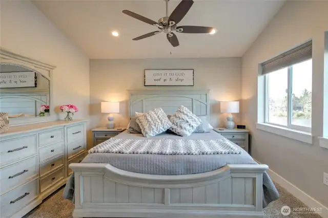 Spacious primary bedroom has ceiling fan, water views, and an en-suite bathroom with walk in closet.