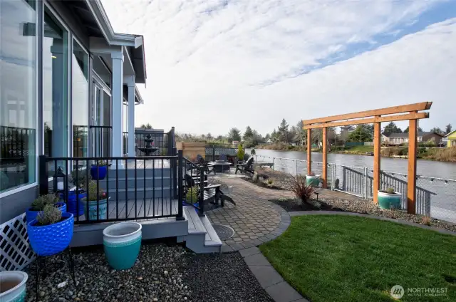 New trex decking leads down to stone patio, yard, fire pit, and dock.