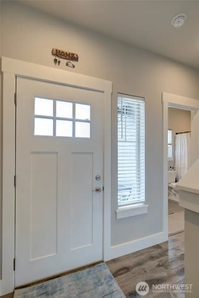 A warm entry in the home leads to main floor suite, as well as living room and dining/kitchen area.