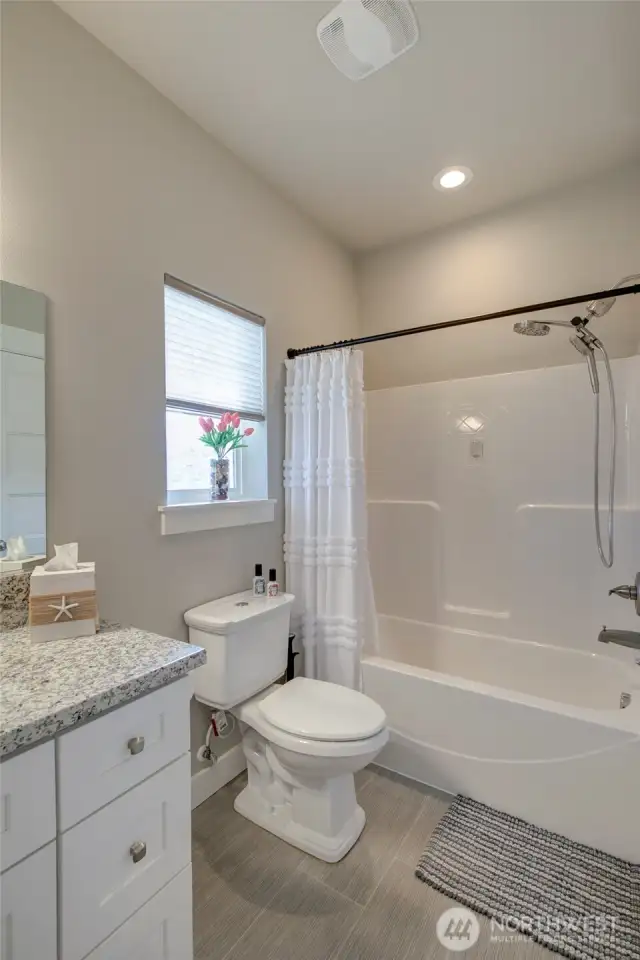 Main floor full bathroom is accessible from the family room/bedroom as well as the hallway.