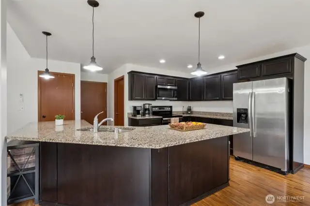 The granite peninsula isn’t just for food prep, it’s got two angles of seating for when your guests want to mingle. Top it off with a sleek French door stainless fridge and three pendant lights, and you’ve got a space that’s all style, all function.