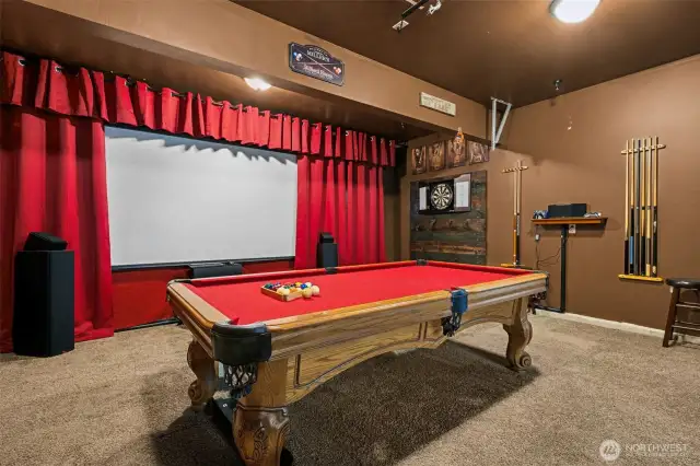 Welcome to the ultimate entertainment cave. With plush carpeting, a theater-style setup with red curtains and a screen, and a pool table all included, this converted garage is more than just a space, it’s a whole vibe. Movie night? Pool game? It’s all here.