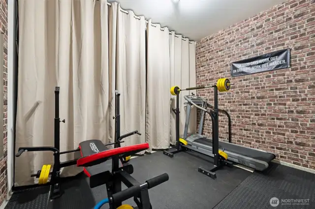 Who needs a gym membership when you've got this converted garage? Equipped with everything you need and carpet tiles for comfort, this space is complete with a rustic brick accent wall and floor-to-ceiling curtains that cleverly hide your storage. Gym goals, anyone?