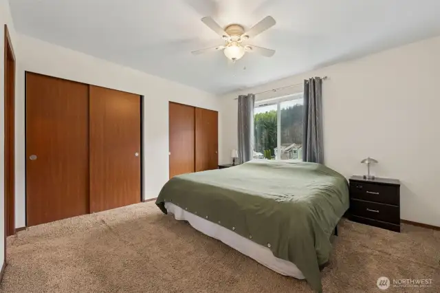 In this primary suite, you’ve got it all: two large closets for plenty of storage, a white ceiling fan to keep things breezy, medium brown carpeting for warmth, and a large window to brighten the space. A relaxing retreat, just for you.