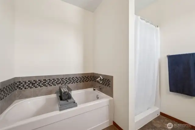 When you’re ready to unwind, this primary suite bath has you covered. Deep soaking tub with a glass tile-accented backsplash for those spa vibes, plus a shower that’s just waiting for you to step in. Add in the vinyl flooring, and you’re looking at the perfect mix of comfort and convenience.