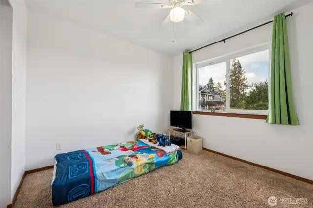 Light, bright, and cozy, this second bedroom features light brown carpet, a large window for natural light, and a white ceiling fan to keep things cool. It’s the perfect spot for whatever you need: sleep, study, or relaxation.