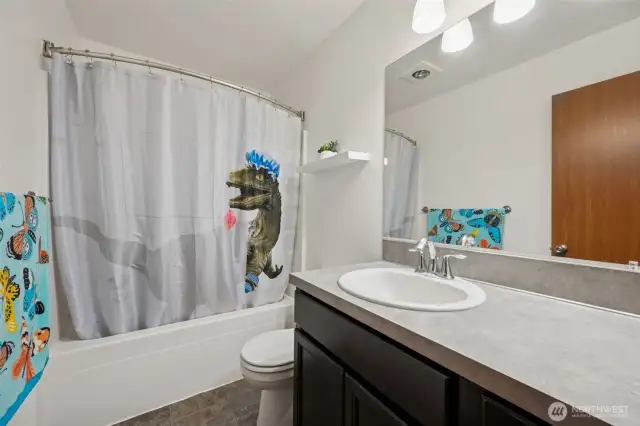 Plenty of space to spread out in this main bathroom! With an extra-long counter for all your beauty and grooming needs, vinyl flooring for simplicity, and a full bathtub/shower combo, it’s a no-fuss, practical bathroom with everything you need.