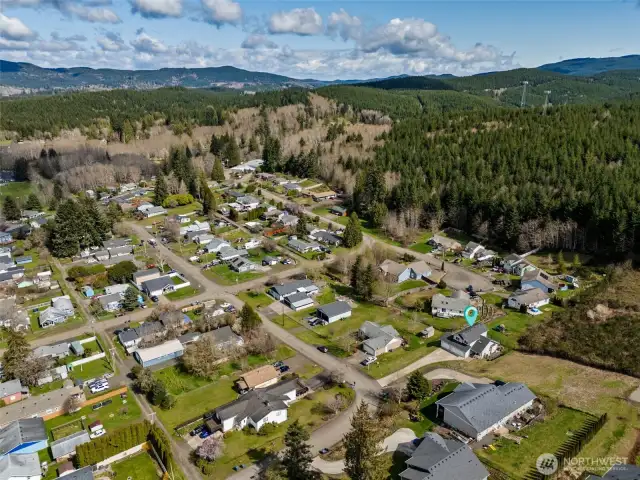 Here’s your “wow” moment: a bird’s-eye view that confirms you’re not just buying a house, you’re claiming a slice of the Pacific Northwest. That forested backdrop with rolling hills? It’s like living in a Bob Ross painting!