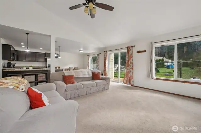 This is the kind of living room that plays it cool but knows it's the star. Oversized windows serve backyard views all day, the ceiling fan is on standby for drama control, and the open layout says “go ahead, multitask.” It’s cozy, it’s functional, and it already knows where your favorite chair will go.