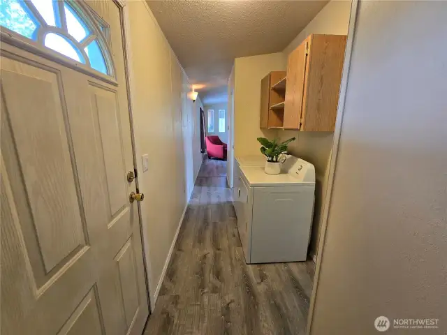 Hallway from back bedroom looking towards living room/kitchen. W/D convey with home.