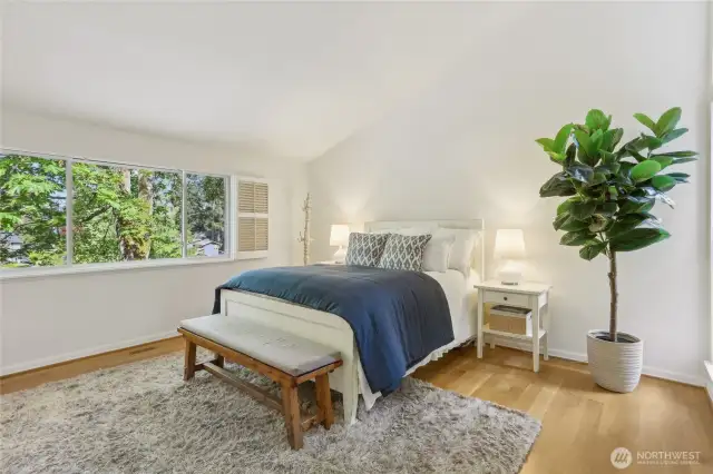 Upper level primary bedroom with vaulted ceilings and peek-a-boo mountain views.