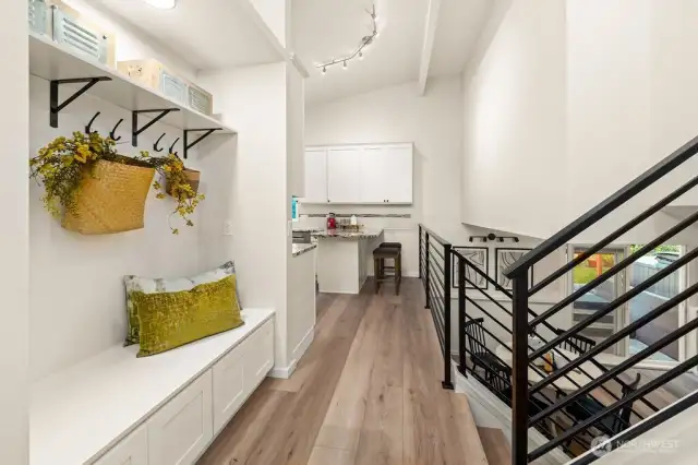 Foyer with seating, coat hooks and storage.