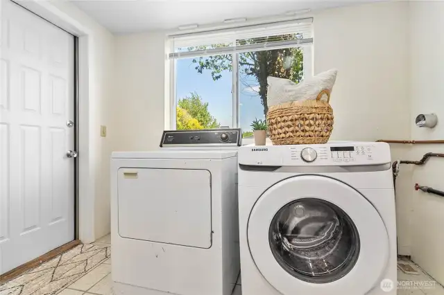 Good-sized utility room with washer, dryer, and an additional entrance for convenience.