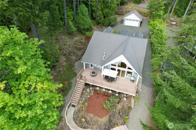 Gorgeous view of large deck and stairway leading to lake surrounded by beautiful landscape!