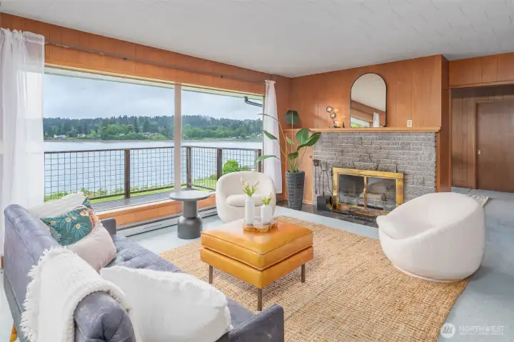 Living room with walls of windows & wood burning fireplace