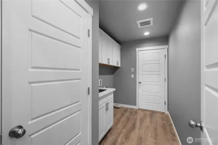 Utility room, pantry door on the left. Utility sink! Garage door straight ahead.