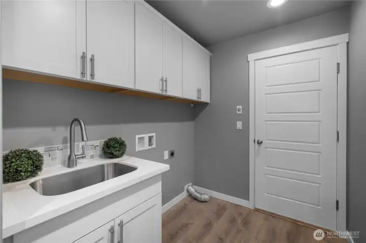 Utility sink, storage above, laundry hookups.
