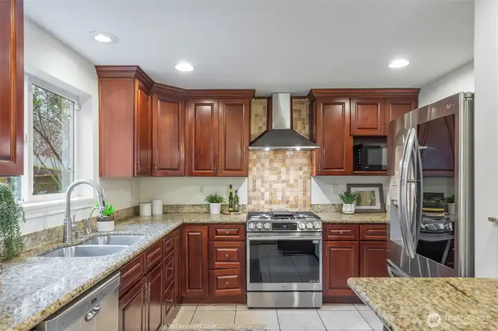 A well appointed kitchen with granite counters, new stove, fridge and microwave...