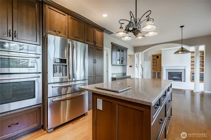 Beautiful Kitchen with deluxe cabinets and Quartz counters and upgraded Stainless appliances. Door to the left goes to the half bathroom and laundry room and through to the garage. Also goes to the formal dining/Family Room.