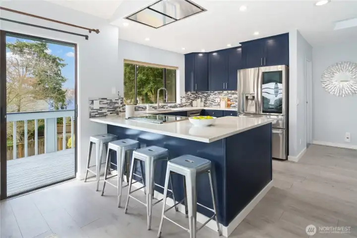 New kitchen with beautiful navy cabinets, quartz, designer tile, induction range, special vent hood flush to the ceiling and coffee bar!