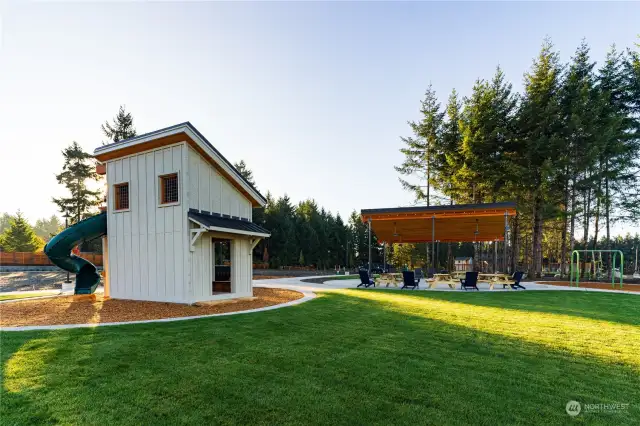 Along with expansive play fields, the Park provides a dedicated play area featuring a wooden train, a playhouse structure complete with a twisty slide and a swing set, ensuring children have plenty of options for outdoor recreation.