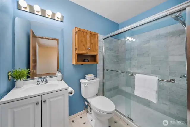 Primary bathroom has been updated to include this beautifully tiled shower with glass doors.